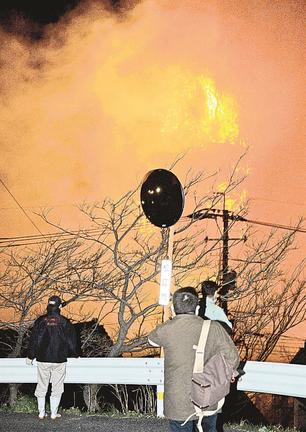 燃え上がる山や民家を見る人たち＝１日午後７時１２分、松江市島根町加賀