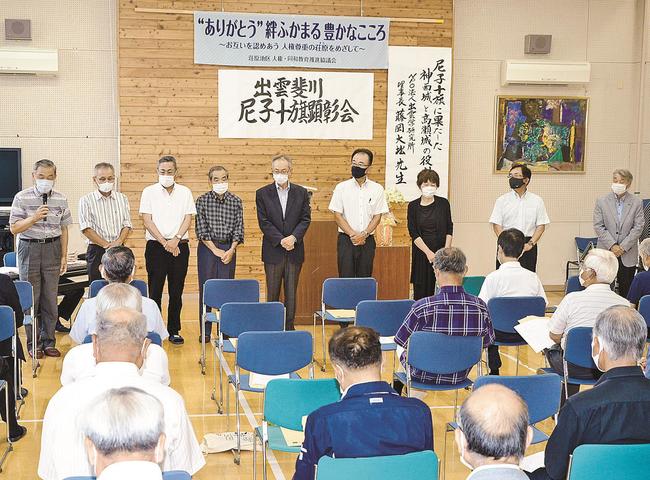 集まった会員らにあいさつをする役員たち＝出雲市斐川町荘原、荘原コミュニティセンター
