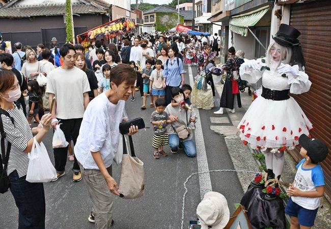 人形になりきるパフォーマンスをする大道芸人（右端）