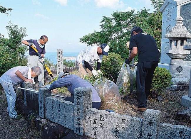 「於國塔」の周辺を清掃する楽成会のメンバーら＝出雲市大社町杵築北、奉納山公園