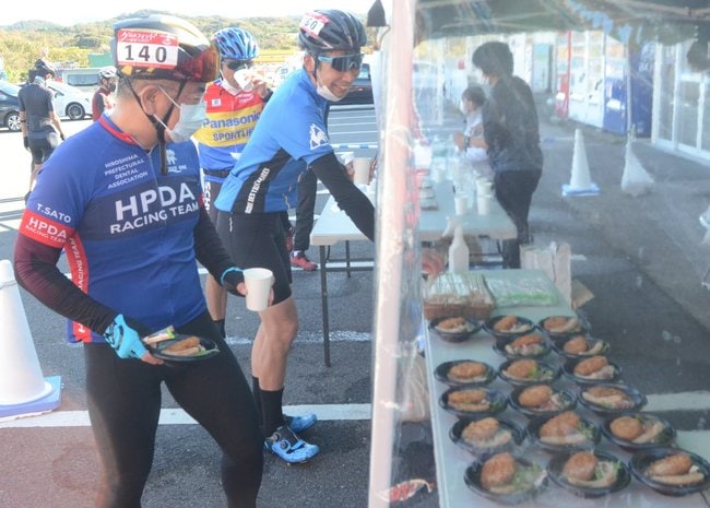 休憩所で地元食材を使った料理を手に取る出場選手=江津市後地町、神楽の里舞乃市