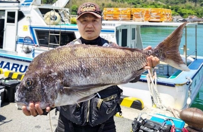 １メートル、９・２キロのマダイを持つ難波聖司さん＝６月２日（松尾丸提供）