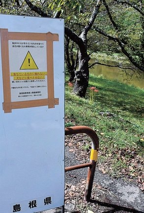河川敷近くに立てられた注意喚起の看板＝雲南市三刀屋町三刀屋
