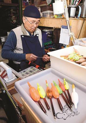 木の切り出しから浮力の調整、塗装まで１本１本の全工程を一人で手掛ける正田宗雄さん＝島根県邑南町中野