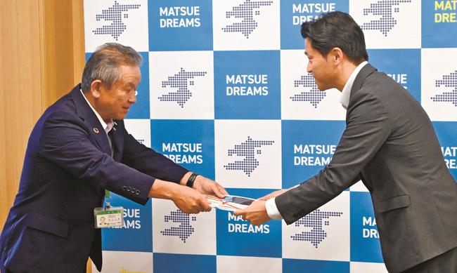 太陽光外灯の目録を渡す田中正彦社長（左）＝松江市末次町、市役所