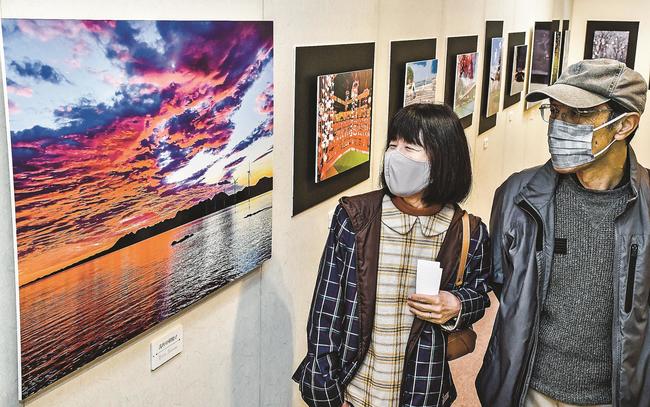 瞬間と構図にこだわった風景写真を鑑賞する来館者＝江津市桜江町川戸、今井美術館