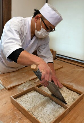 年越しを前に多くの注文を受け、そばを打つ職人=松江市奥谷町、神代そば