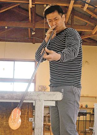 ガラスに息を吹き込み、制作に励む川辺雅規さん＝出雲市斐川町出西、ガラス工房Ｉｚｕｍｏ