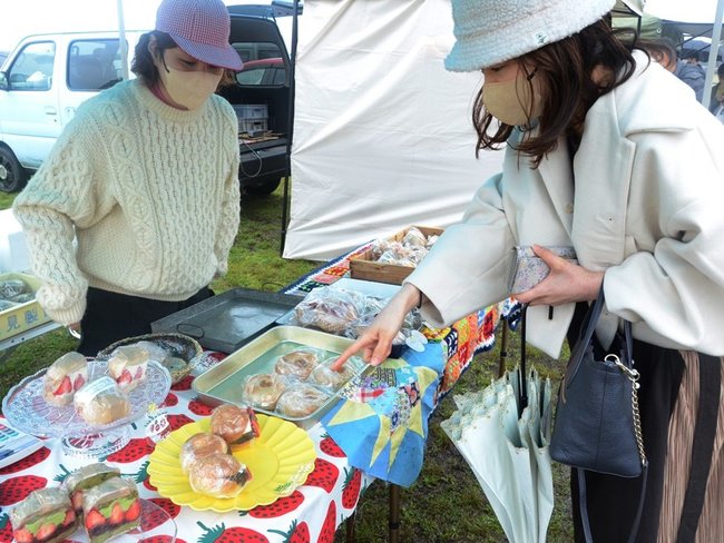 イチゴをふんだんに使ったサンドイッチを品定めする来場者（右）＝安来市穂日島町、中海ふれあい公園