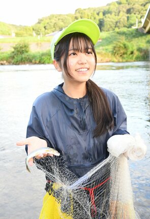 網で捕ったアユを手に笑顔を見せる真庭悠萌さん=益田市向横田町、高津川