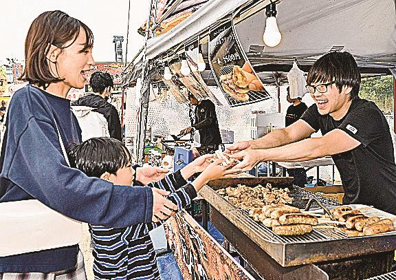 目当ての肉料理を購入する親子連れ（左）＝松江市学園南１丁目、旧島根県立プール跡地