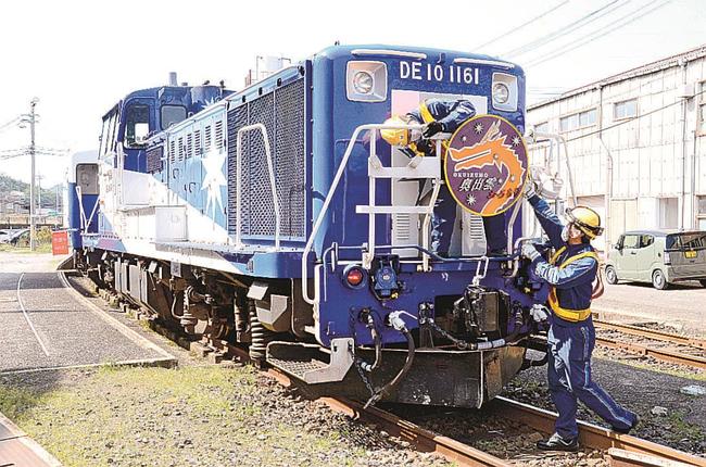 ヘッドマークを取り付ける作業員＝米子市目久美町、ＪＲ後藤総合車両所運用検修センター