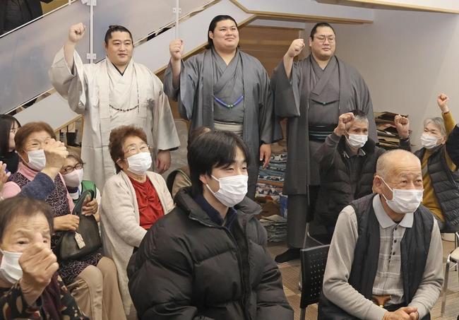 能登半島地震の避難所を訪れ、被災者と写真に納まる大相撲の（奥左から）遠藤、大の里、輝＝６日、石川県内灘町