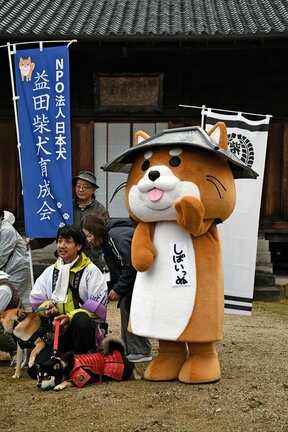 昨年１１月の全国山城サミット益田大会に登場したしばいっぬ（右）。隣が柴田健治さん＝益田市東町、万福寺