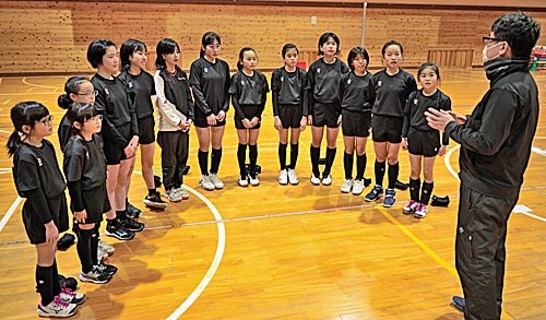 宇山広繁監督（右）の話を聞くかわもとジュニアバレーボールクラブのメンバー＝島根県川本町川本、川本小学校体育館