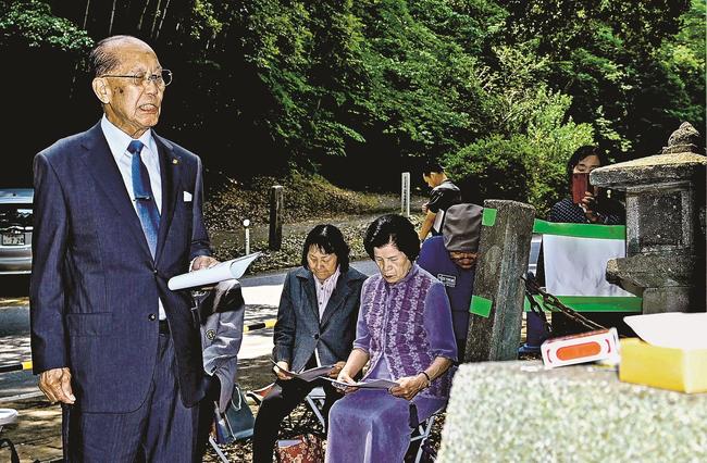 岸静江国治の墓前で和歌を吟じる東俊風さん=益田市多田町