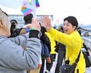 参加者とハイタッチし、喜びを分かち合う佐藤みどりさん