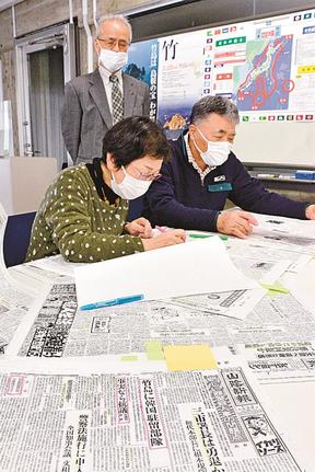 山陰中央新報の前身の紙面の中から竹島に関連した記事を調べる調査員＝松江市殿町、島根県竹島資料室