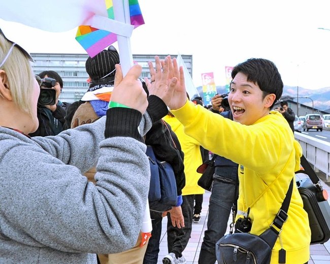 参加者とハイタッチし、喜びを分かち合う佐藤みどりさん