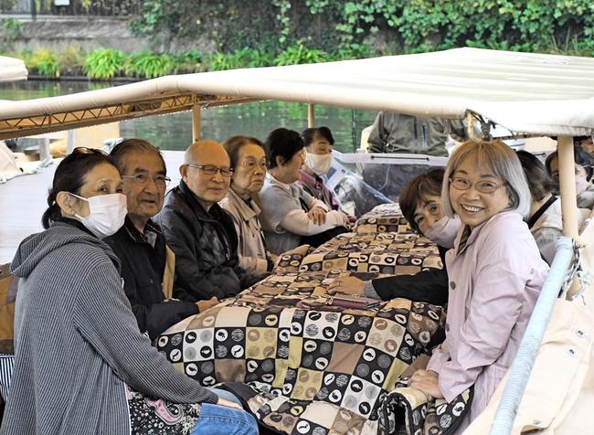 こたつで暖まりながら、堀川遊覧船を楽しむ観光客＝2023年11月、松江市殿町の松江城周辺