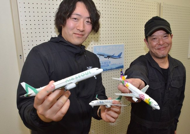 米子空港で初となる旅客機のプラモデル展を開いた塚田亮太郎さん（左）たち＝境港市佐斐神町
