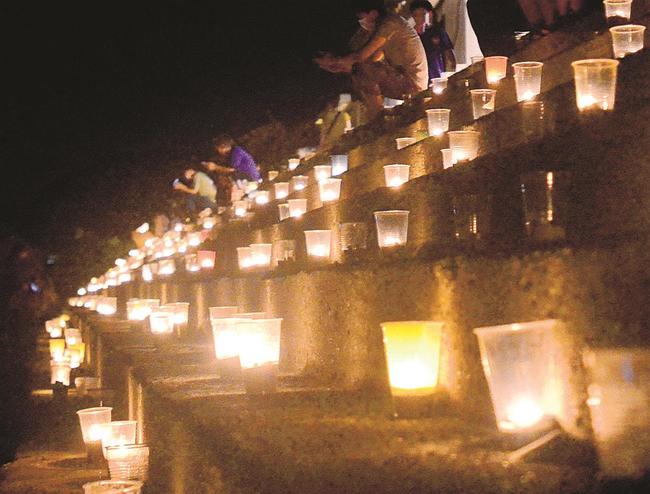 波根海岸をほのかに照らすろうそく＝大田市波根町