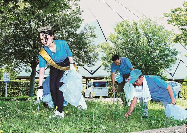 出雲ドーム前で清掃活動する青年部の会員と幸田芙沙さん（左）＝出雲市矢野町