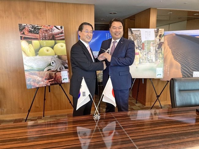 エアソウルの趙鎭滿代表理事（右）と握手を交わす平井伸治鳥取県知事＝ソウル市内（提供）