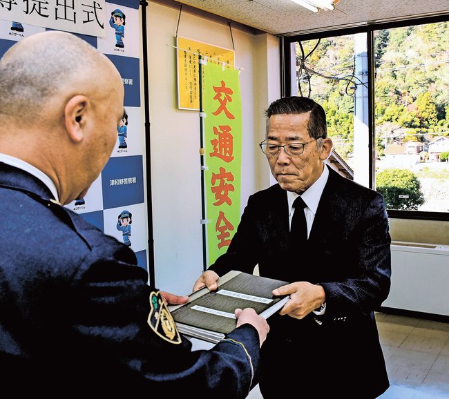 署名簿を提出する中谷保宣会長（右）＝島根県津和野町森村、津和野署