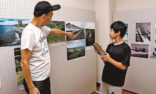 高嶋敏展さん（左）の解説を聞く来場者＝出雲市佐田町反辺、スサノオホール