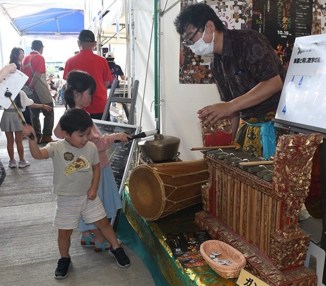 ガムランの楽器の体験をする子どもたち＝松江市向島町、山陰中央テレビジョン放送