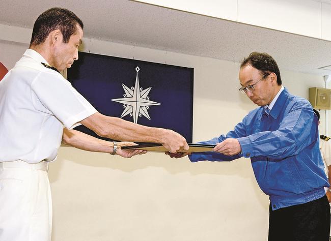 西山博境海上保安部長から感謝状を受け取る桑原正樹さん（右）＝境港市昭和町、境港港湾合同庁舎