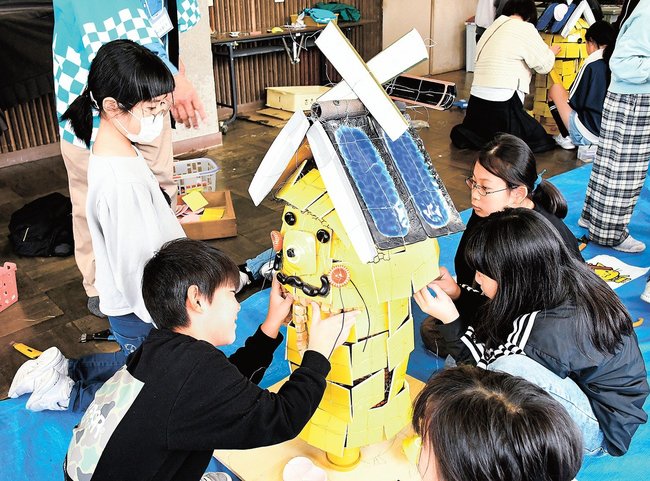 協力して一式飾りの作品を仕上げる児童たち＝出雲市西平田町、平田小学校