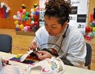 パレード用の面にペイントする参加者＝松江市朝日町、松江テルサ