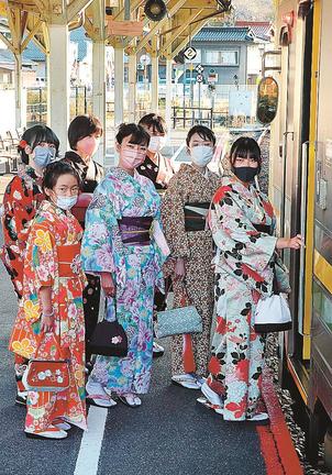 あでやかな着物姿で列車に乗り込む参加者たち＝雲南市木次町里方、ＪＲ木次駅