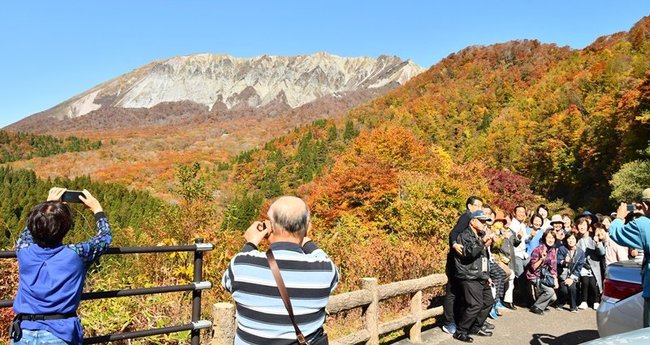 色づいた景色を撮影する観光客＝鳥取県江府町大河原鍵掛、鍵掛峠展望台