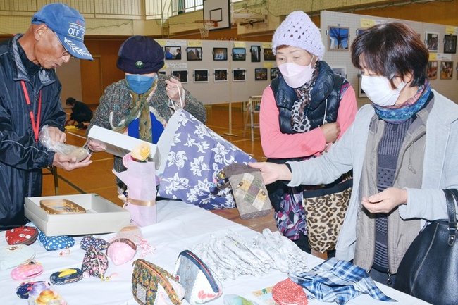 住民が持ち寄った小物入れなどを手にする来場者＝浜田市佐野町、石見まちづくりセンター佐野分館