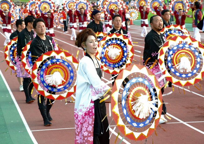 威勢良く、華やかな傘踊りを披露する踊り子たち＝鳥取市布勢、ヤマタスポーツパーク陸上競技場