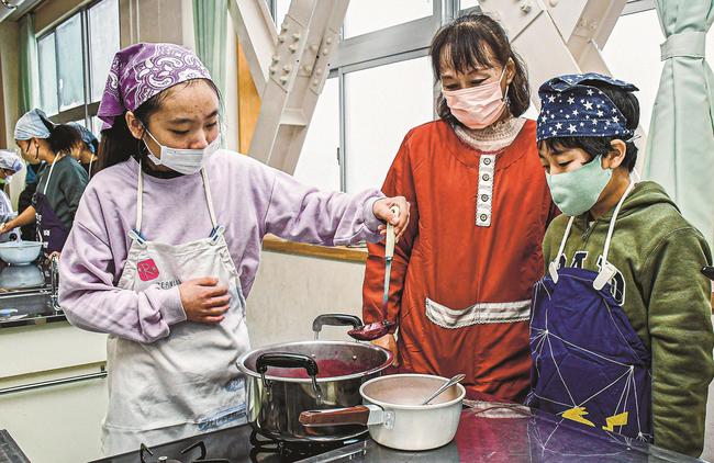 児童のジャム作りを見守る鳶巣環境保全協議会の山崎順子さん（中央）＝出雲市稲岡町、北陽小学校