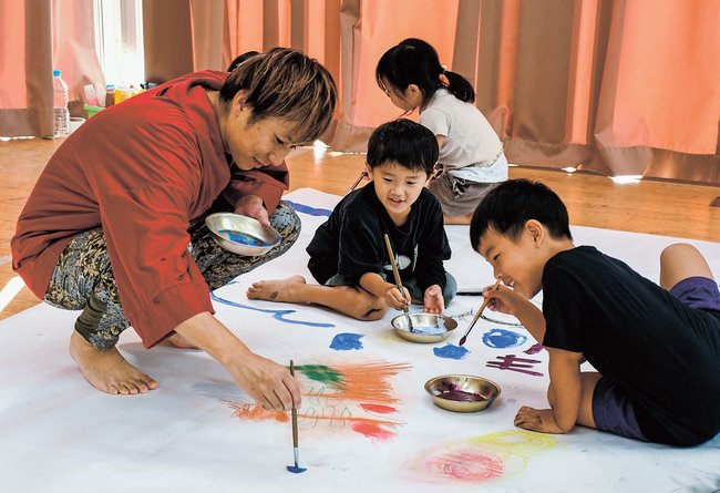 園児と一緒に絵を描くこーたさん（左）＝出雲市西平田町、平田幼稚園