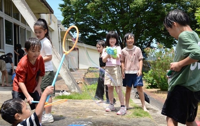 水鉄砲やシャボン玉で遊ぶ子どもたち＝浜田市原井町、旧雲雀丘小学校