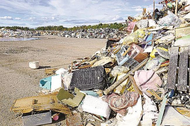 住宅の床上浸水などで出た大量の災害ごみ。秋田の大雨から１カ月たつが、仮置き場に積まれたままだ＝１４日午後、秋田市