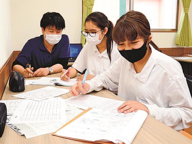 教員免許を持つ従業員（左）に教わりながら児童クラブで勉強に励む女子生徒たち＝出雲市塩冶町、わくわく児童クラブ