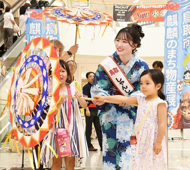 和傘を手に子どもたちと触れ合う田中あかりさん＝広島市南区、ゆめタウン広島