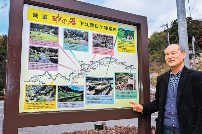 映画「砂の器」ロケ地の案内看板を紹介する植田覚さん＝雲南市大東町下久野