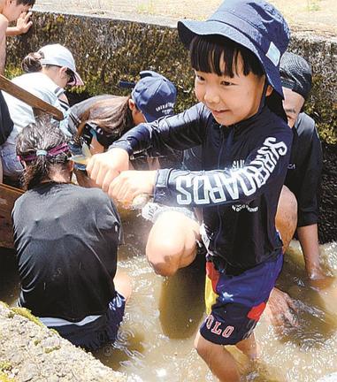 アユを捕まえ、うれしそうな子ども＝出雲市佐田町一窪田、遊好の里