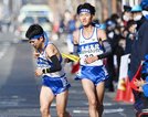 平田の１区石飛翔悟から（右）からたすきを受け、駆け出す２区福間健太＝烏丸 鞍馬口、第１中継所