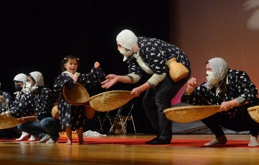 どじょうすくい踊りを体験する外国人の参加者＝安来市古川町、安来節演芸館