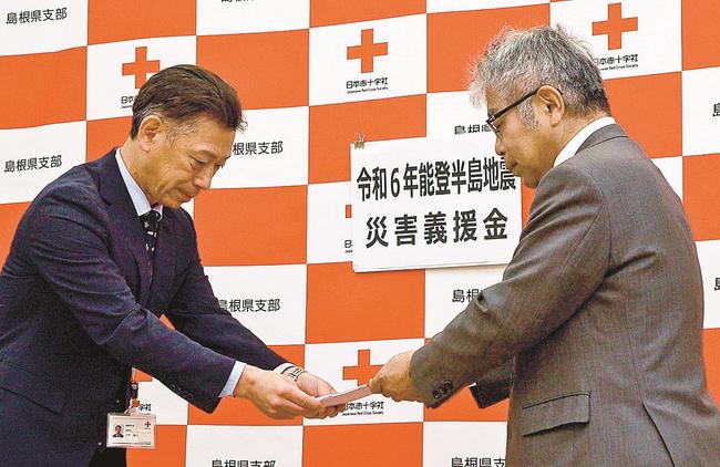 小田川真一理事長から義援金の目録を受け取る小村浩二事務局長(左)=松江市内中原町、日赤島根県支部