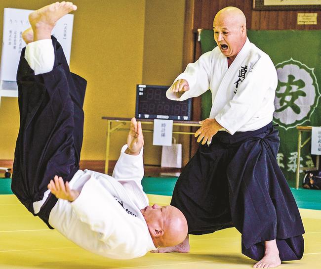 投げ技を見せる雲藩直信流柔道研究会のメンバー＝安来市安来町、市民体育館